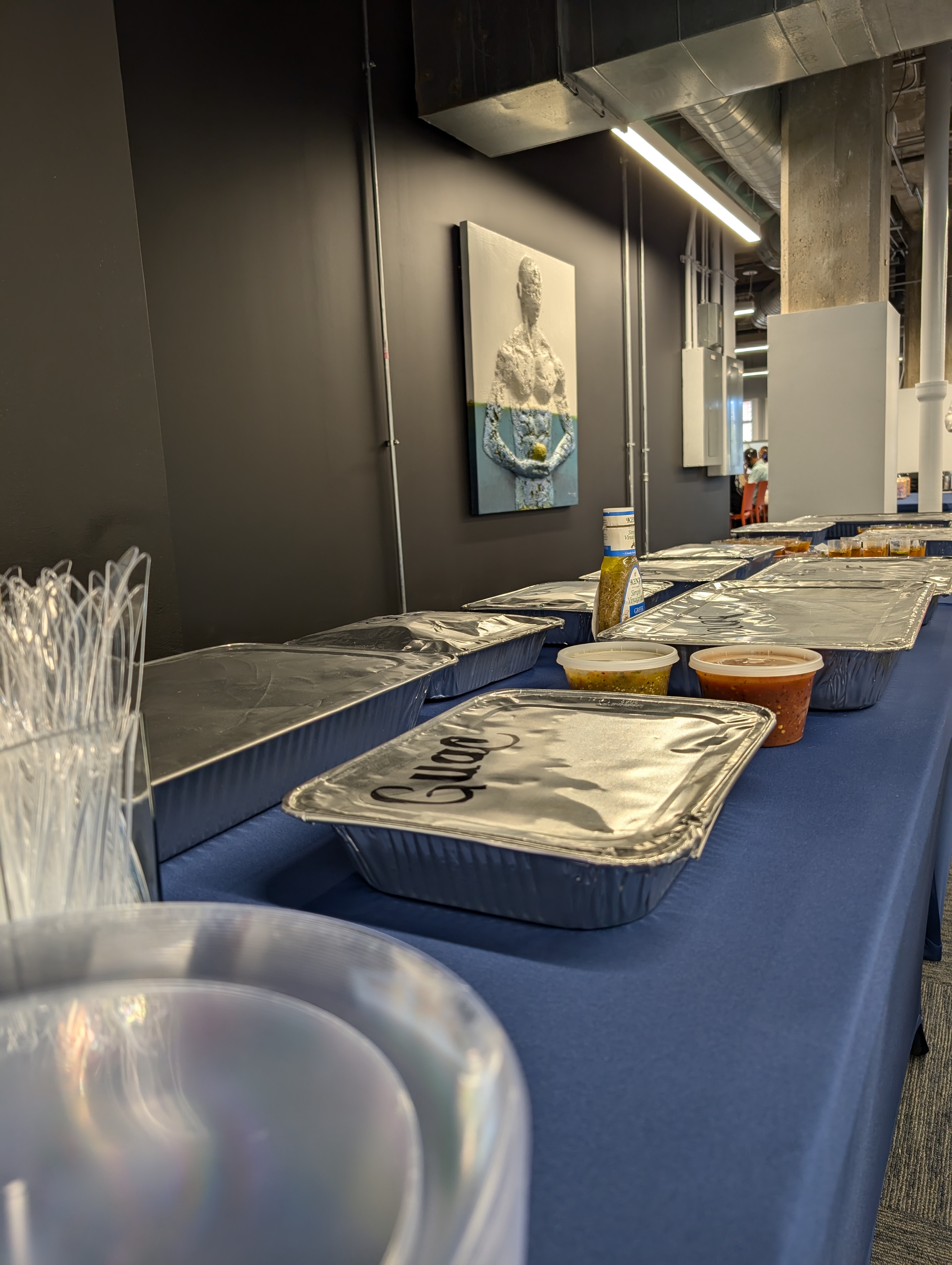 Foil catering trays labeled Guac plus salsas staged for a corporate lunch spread